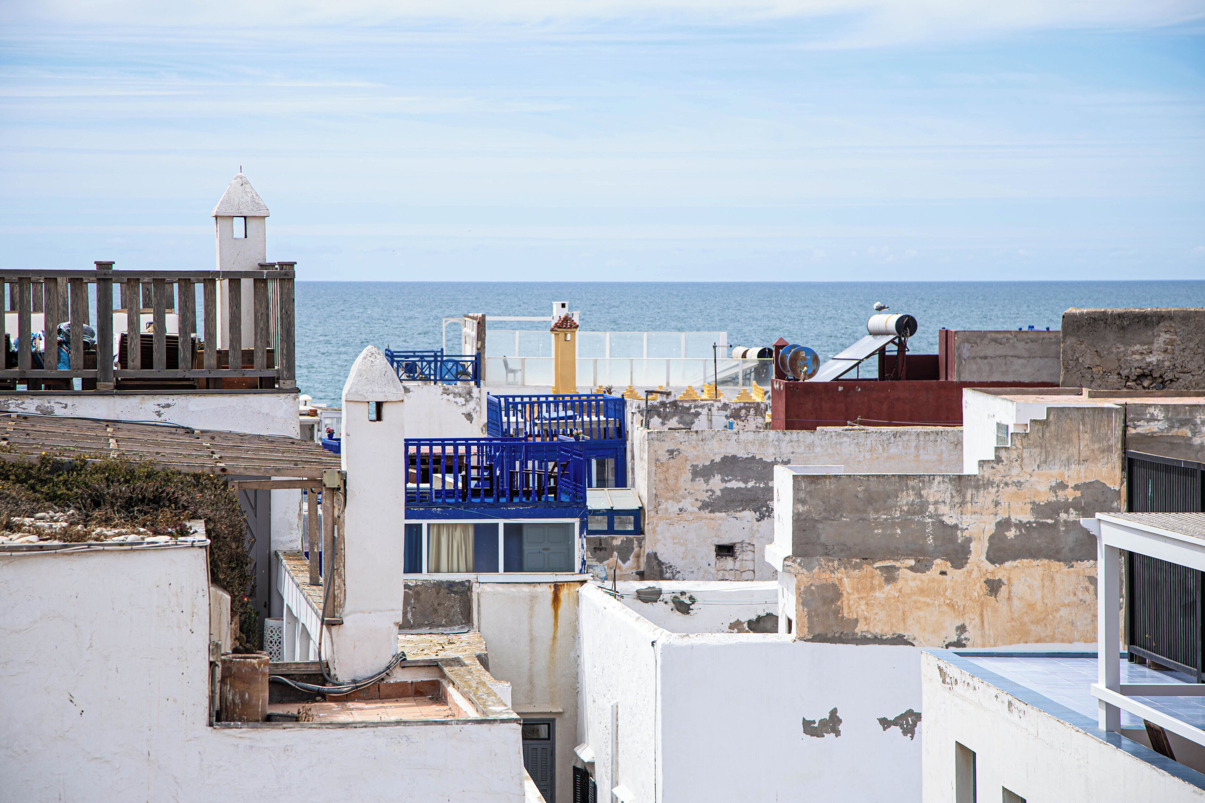 Una zona urbana costera con edificios, un muelle y el mar al fondo.