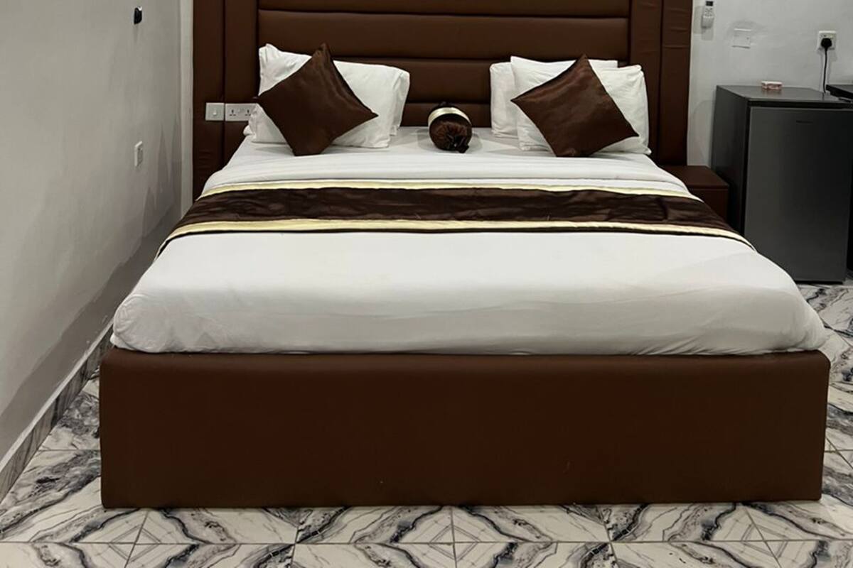 Une chambre d’hôtel moderne avec un grand lit, une table de chevet et une petite table.