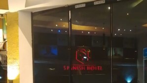 A hotel entrance with a glass door and a neon sign reading 'SPANISH HOTEL.' - Spanish Hotel Ikeja (Lagos)