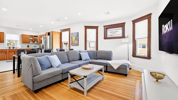 A modern living room with a grey sectional sofa, a wooden coffee table, and a white console table with a decorative bowl. - The Milton Manor 5BR 2BA - Sleeps 10 - Unit 2 (Milton)