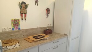 Eine Küche mit Holzarbeitsplatte, weißen Schränken und einem Kühlschrank.