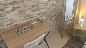 Ein Zimmer mit einem Holztisch, einem Spiegel und einer verzierten Ablagefläche.