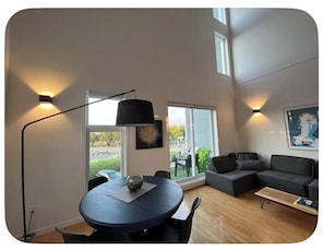 Un salon moderne avec une table ronde, un canapé et une lampe.