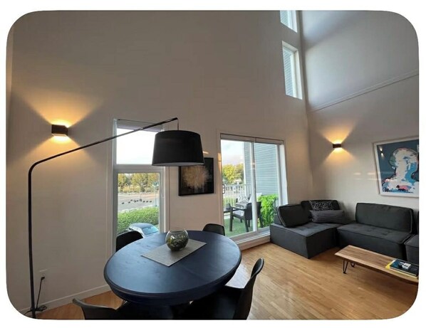 A modern living room with a round table, a sofa, and a lamp.