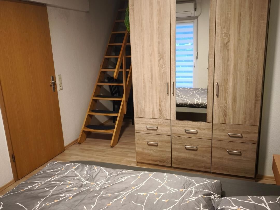 Une chambre à coucher avec un lit, une armoire et une échelle en bois.