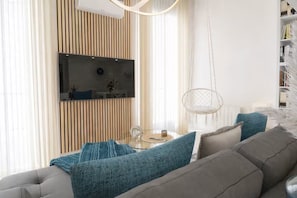 Een moderne woonkamer met een bank, een salontafel en een televisie.