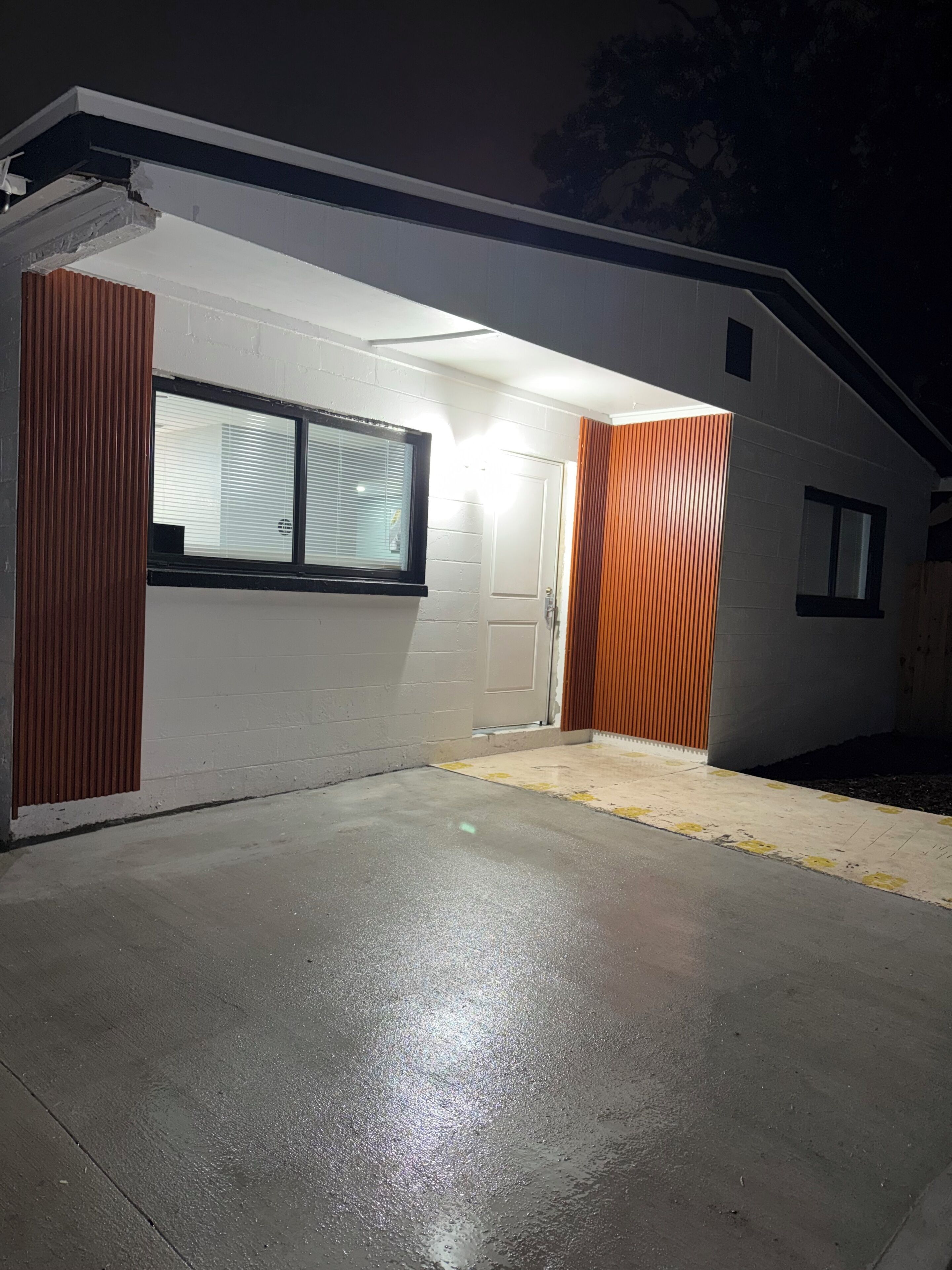 Um edifício moderno com porta de garagem, janela e porta.