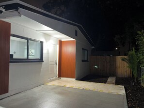 Ein modernes Haus mit Garage, Holzzaun und Betonauffahrt.