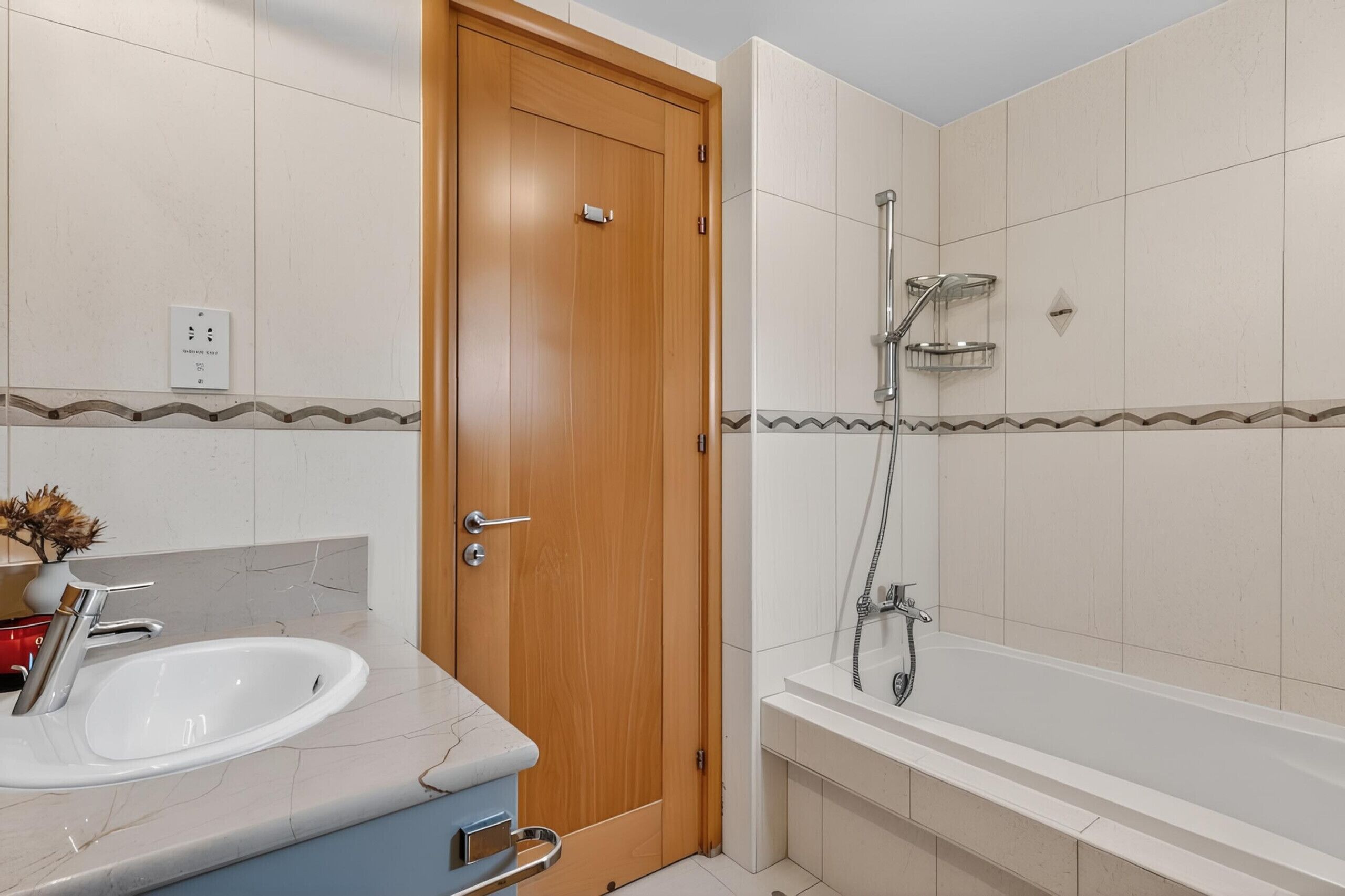 A bathroom with a wooden door, a sink, a bathtub, and a shower.