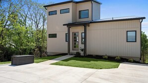 Ein modernes, zweistöckiges Haus mit Eingangsbereich, kleinem Vorgarten und Garage.