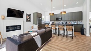 Eine moderne Küche mit Bar, Kamin und einer Couch im Wohnzimmer.
