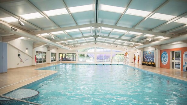 An indoor swimming pool with clear lanes, a diving platform, and a covered roof structure. - Caravan Sleeps 5 - Decking, Parking, Pet Friendly (Blackpool)