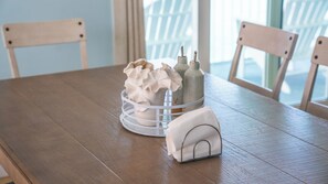 A wooden table with a white basket containing a vase and bottles, and a small white house-shaped object. - Marathon Oceanfront 4BR, 3.5BA Private Pool 60’ Boat Dock (Marathon)
