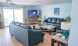 Una sala de estar con sofá, mesa de centro, televisor y objetos decorativos.