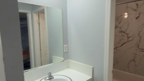 Un baño con lavamanos blanco, un espejo y una bañera.