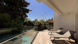 A wooden deck with glass railings, outdoor seating, and a clear view of the sky. - Carthage Villa 3BR Luxury Pool Garden (Carthage)