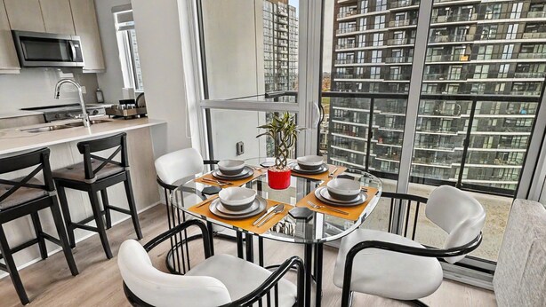 A modern kitchen with a microwave, stove, and sink. - Modern 2BR+Den Condo near Square One | Sleeps 6 | Mins to Pearson YYZ (Mississauga)