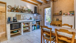 A compact kitchen with a microwave, toaster, and wooden cabinets.