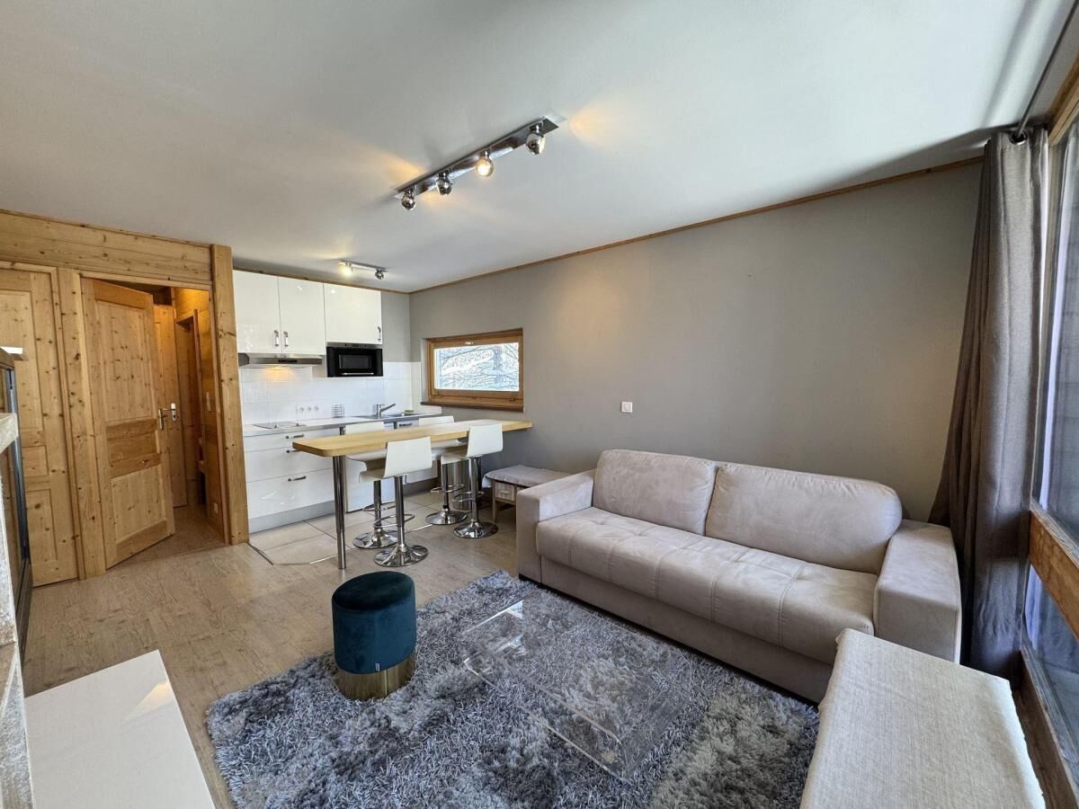 A modern living room with a sofa, a coffee table, and a dining area with chairs.