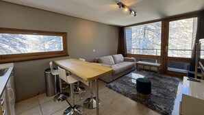 Una cocina moderna con comedor, ventanas amplias y vistas a un paisaje nevado.