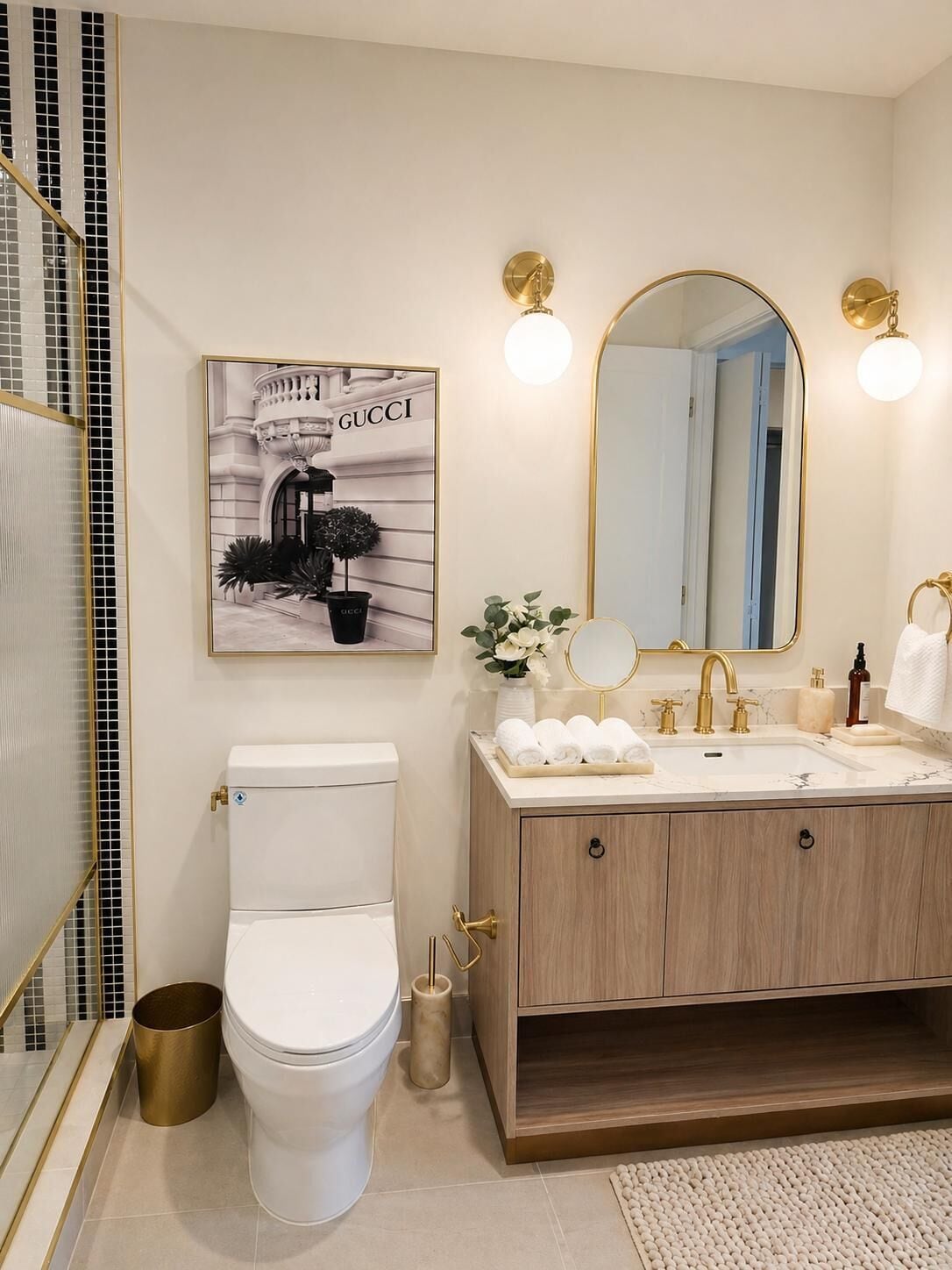 A modern bathroom with a toilet, vanity, and a large mirror.