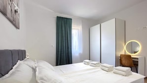 A hotel room with a bed, a desk with a mirror, and a chair. - Two Bedroom Apartment With Terrace (Pula)