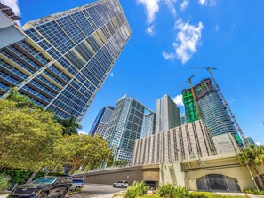 A cityscape with high-rise buildings, a construction site, and a bridge. - Luxury Viceroy Brickell Condo | Sea View & Parking (Miami)