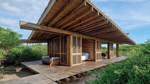 Eine Holzhütte mit geneigtem Dach, einer Veranda und einer kleinen Terrasse.