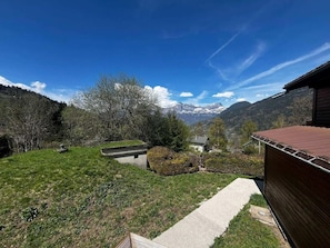 A rural landscape with a house, a pathway, and a view of mountains. - Chalet, terrace, balcony, tv, ski locker, 38m², Saint Gervais (Saint-Gervais-les-Bains)