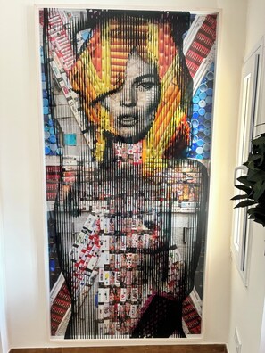 A wall with a large, colorful artwork featuring a woman's face and various objects. - Luxurious apartment garden pool beach 300 meters view of Africa Gibraltar (La Línea de la Concepción)