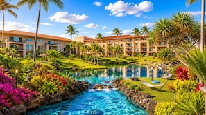 A resort with a swimming pool, palm trees, and a building with balconies. - Marriott's Waiohai Beach Club Resort + Resort Amenities Included (Koloa)