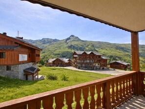 A wooden chalet with a stone foundation, multiple wooden buildings, and a mountain view. - Ground floor, balcony, tv, ski locker, 35m², Les Menuires (Les Menuires)