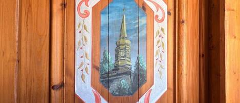 Una porta de fusta amb el número 25 i una representació pintada d'una torre.