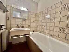 Ein Badezimmer mit Badewanne, Waschbecken und Spiegel.