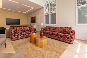 A modern living room with two sofas, a TV, and a large window.