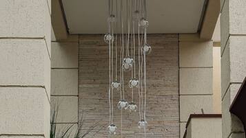 A modern interior with a hanging light fixture, a wooden wall, and a potted plant.
