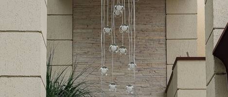 A modern interior with a hanging light fixture, a wooden wall, and a potted plant.