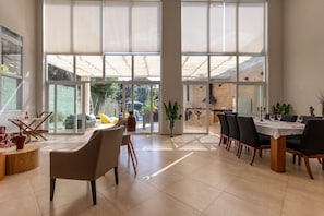 Un comedor amplio con ventanas grandes, una cocina moderna y vistas al exterior.