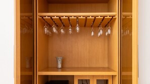 A wooden cabinet with a television, a vase, and a wine rack.