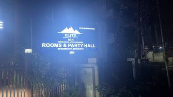 A sign for Elite Inn Dehradun, Uttarakhand, Rooms & Party Hall with contact numbers.