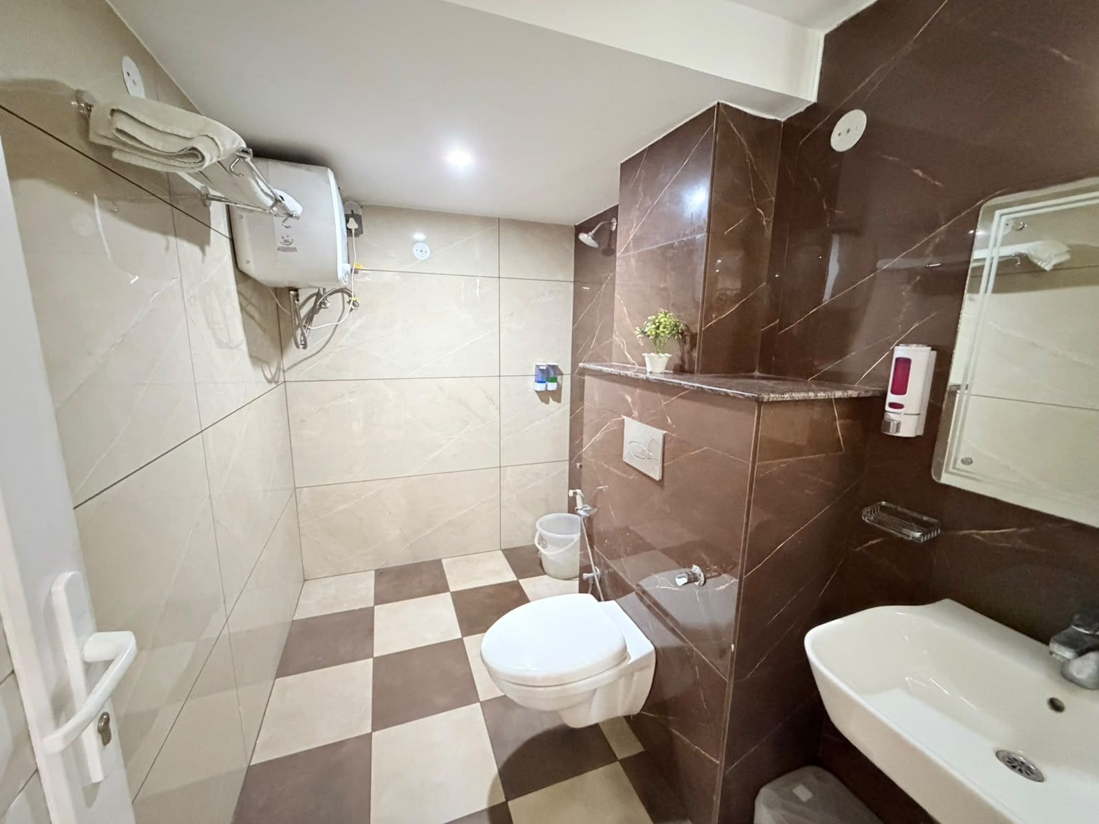 Baño con inodoro, lavamanos y zona de ducha.