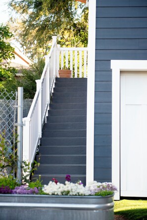 A staircase with white railings leading to a door, surrounded by a garden with various plants and flowers. - Suite in the Foothills of LA for Extended Stays (La Crescenta-Montrose)