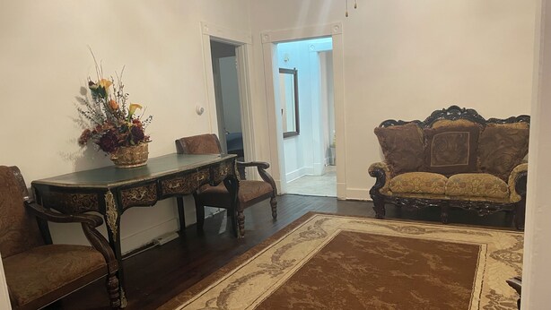 A room with a dining table, two chairs, a sofa, and a large rug. - 2-bedroom building in cool Richmond with refreshing AC (Richmond)