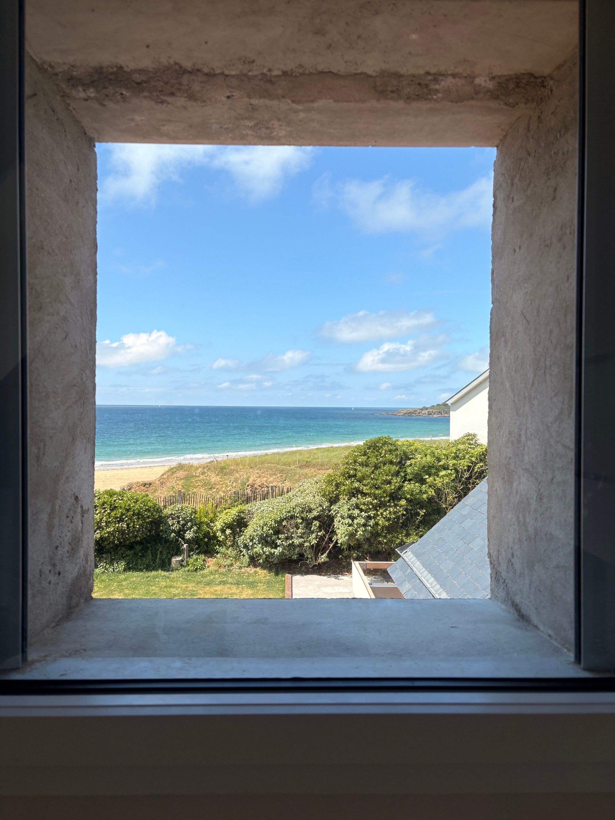 A view through a window of a beach with a clear sky.