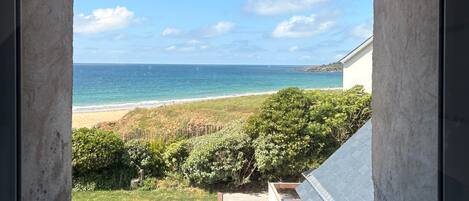 A view through a window of a beach with a clear sky.