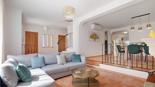 A modern living room with a sofa, coffee table, and a staircase leading to a dining area. - Villa 'Modern  in Olhao' with Mountain View, Wi-Fi and Air Conditioning (Quelfes)