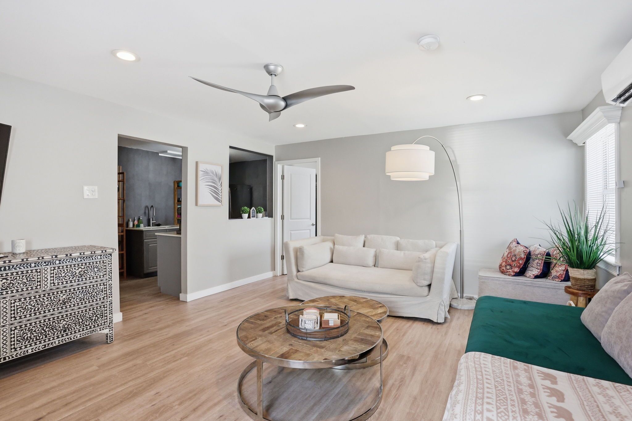 A modern living room with a sofa, coffee table, and a ceiling fan.