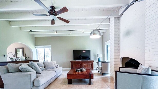 Una sala de estar con sofá, mesa de centro, televisión y chimenea.