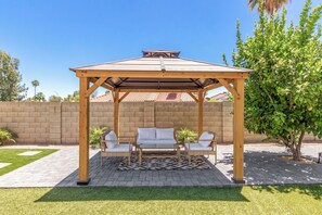 A wooden gazebo with a tiled roof, two cushioned benches, and a patterned rug. - Scottsdale 4 Bdrm Retreat, Pool, Spa, Prime Location! (Scottsdale)