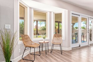 A room with large windows, wicker chairs, a small table, and a potted plant. - Scottsdale 4 Bdrm Retreat, Pool, Spa, Prime Location! (Scottsdale)